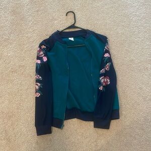 Teal jacket with navy sleeves.